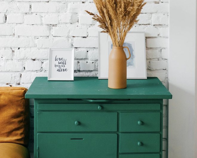 a drawer with a vase and a portrait on it